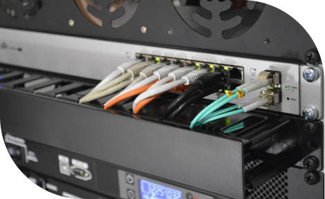 Various cables are plugged into the back of a PLC or server