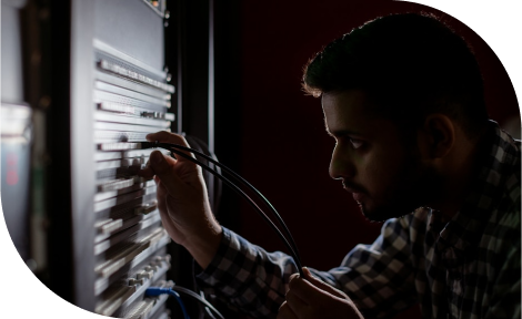 A man appears to be setting up or testing a server cabinet